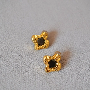 Macro shot of gold-plated flower studs with wrinkled texture and black zircon stones