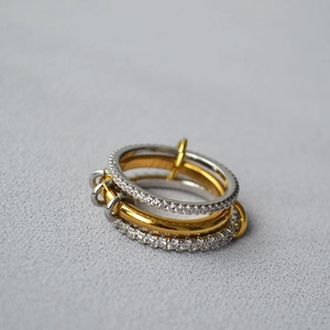 Close-up of three linked rings with white zircon pavé and golden band detail