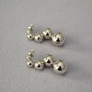 Detailed view of silver gradient multi-bead earrings with four polished spheres