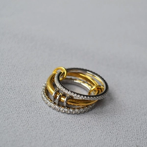 Detailed view of interconnected mixed-metal multi-layer rings with pave diamond accents