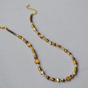 Detail of beaded tiger eye necklace with gold lobster clasp and faceted glass beads