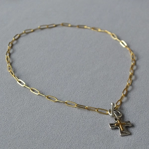 Détail du collier chaîne trombone dorée vintage avec pendentif croix bicolore et fermoir à bascule