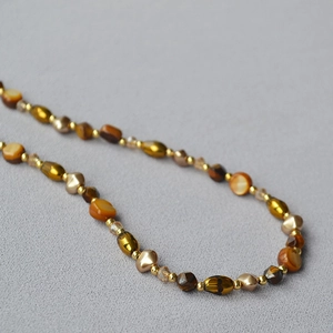 Vintage Maillard beaded necklace with tiger eye stones and amber accents on grey fabric
