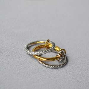 Close-up of interlocking multi-layer rings with micro-pave crystals in mixed metal tones
