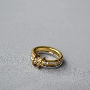 Macro detail of multi-layered gold and silver ring featuring crystal pavé setting