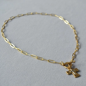 Détail de la chaîne trombone en laiton avec pendentif double croix dorée et fermoir à bascule OT