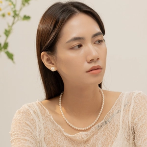 Gros plan d'un collier de perles élégantes et boucles d'oreilles assorties sur un mannequin