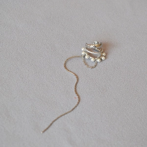 Silver fringe clip earrings with pearls and zircon tassels on minimalist gray background