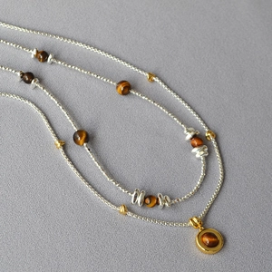 Macro shot of double-layered beaded necklace with tiger eye stones and silver accents