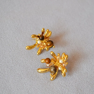 Macro detail of firework studs with tiger eye stones, pearls and golden branch textures