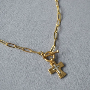 Détail du collier chaîne trombone avec croix dorée martelée et fermoir à bascule