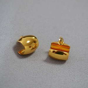 Detailed view of chunky geometric gold earrings with a high-polished mirror finish