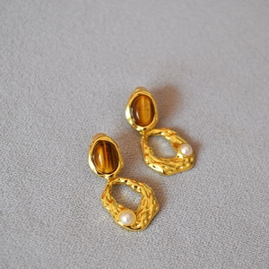 Vue détaillée des boucles d'oreilles en œil de tigre avec texture laiton doré et perles
