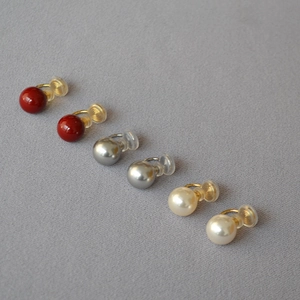 Vue détaillée de trois clips d'oreilles perles avec monture dorée et coussinets en silicone