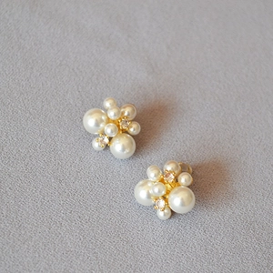 Gros plan détaillé des boucles d'oreilles dorées avec perles blanches et zircons brillants