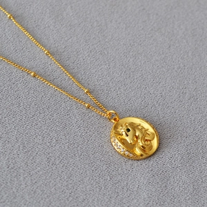 Collier licorne en laiton plaqué or avec œil en pierre verte et détails en zircon