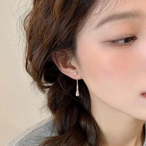 Minimalist silver long teardrop earrings with elegant double pearl accents on model