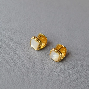 Elegant gold square hoop earrings with white mother of pearl inlay on textured background