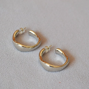 Detailed view of silver irregular wavy lava stud earrings with secure silicone backings