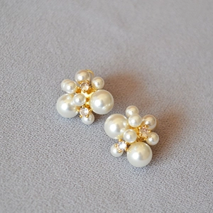 Vue détaillée des boucles d'oreilles en perles avec centres en zircon sur base dorée