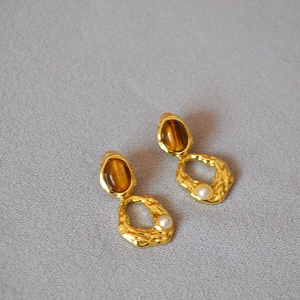 Détail de boucles d'oreilles avec pierre œil de tigre et petite perle sur laiton doré martelé