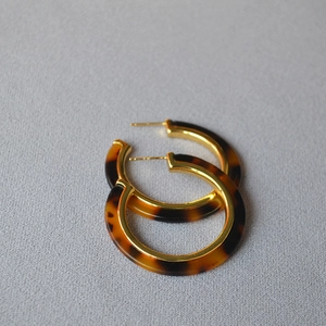 Detail of vintage tortoiseshell leopard print large hoop earrings with gold metal inlay