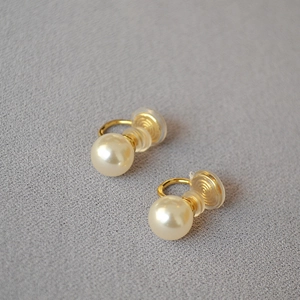 Détail de clips d'oreilles en perles avec finition dorée et coussinets en silicone