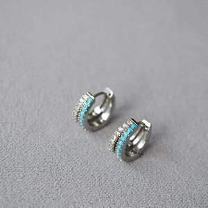 Detailed close-up of silver-plated hoop earrings with turquoise beads and pavé crystals