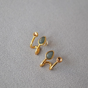 Vue détaillée de boucles d'oreilles dorées avec pierre goutte et design à double ligne