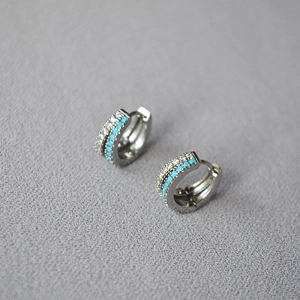 Macro detail of huggie earrings with double-row turquoise and white cubic zirconia