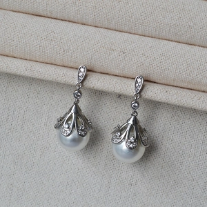 Close-up of vintage pearl drop earrings with cubic zirconia and silver metal setting