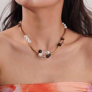 Retro tiger eye and pearl beaded necklace with gold textured tubes on a model's neck