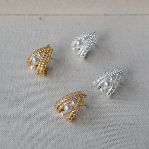 Macro detail of French vintage lace earrings with delicate pearls and sparkling diamonds