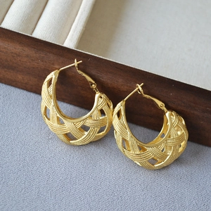 Detailed macro view of gold-plated hollow mesh weave pattern on wide C-shaped hoop earrings