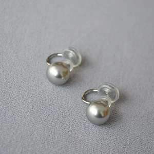 Détail de boucles d'oreilles clips perles argentées avec clips en U et coussinets
