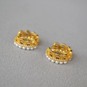 Vue détaillée de boucles d'oreilles couronne vintage en or avec perles et zircons