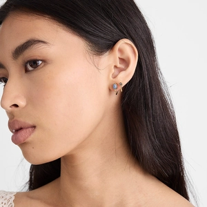 Boucles d'oreilles dorées style français avec pierre goutte d'eau bleue sur mannequin