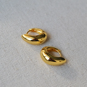 Detail of S925 hallmark on polished gold-plated brass huggie earrings for women