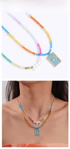 Détail du collier de perles arc-en-ciel avec pendentif soleil lune et perles baroques