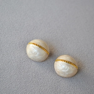 Détail de boucles d'oreilles vintage en émail perlé avec chaîne dorée et tiges en argent 925