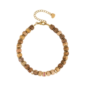 Detail of beaded gemstone bracelet with gold-plated spacers and a red zircon charm