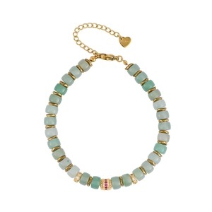 Close-up of gold stainless steel bracelet with green stones and zircon-set charm