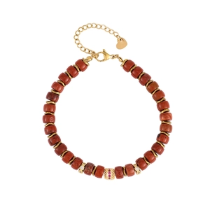 Macro shot of red agate beads with gold spacers and crystal encrusted gold charms