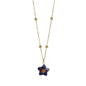 Détail d'un collier vintage doré avec pendentif étoile bleue et pierre rouge
