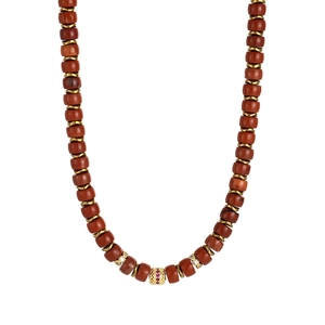 Detail of 18K gold necklace with reddish-brown beads and hollow gold pendant with pink stone