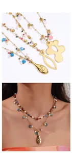 Détail du collier doré multi-rangs avec perles colorées et pendentifs poisson et fleur