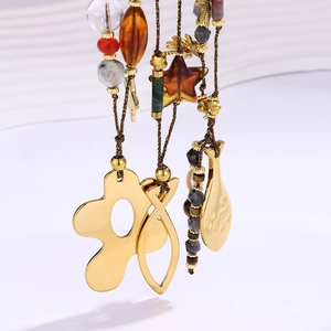 Gros plan du collier océan avec pendentifs poissons dorés et perles en pierre naturelle