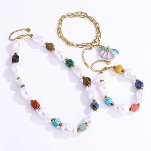 Detailed view of baroque pearl necklace set with colorful gemstones and conch shell pendant