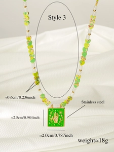 Detailed macro view of a tarot-style green rectangle pendant on a beaded stainless steel necklace