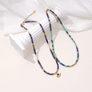Lapis lazuli beaded necklace set with white pearls and gold spacers on Greek pillars